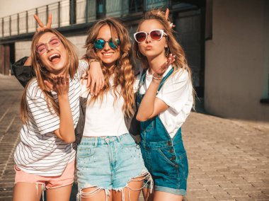 Moda yazlık giysiler üç genç güzel gülümseyen hipster kız Portresi. Seksi kaygısız kadınlar sokak arka planda poz. Güneş gözlüğü ile eğlenen pozitif modeller. Sarılma