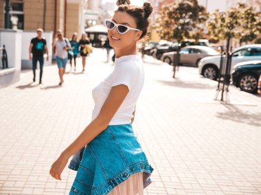 Boynuzları saç modeli yaz hipster ceket kot elbise giymiş güzel gülümseyen model. Seksi kaygısız kız sokak arka planda poz. Trendy komik ve pozitif kadın güneş gözlüğü eğlenmek