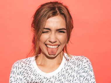 Genç ve güzel gülümseyen hippi kadının yakın plan portresi. Moda pozitif kız çıldırıyor. Pembe duvarda izole edilmiş bir model.