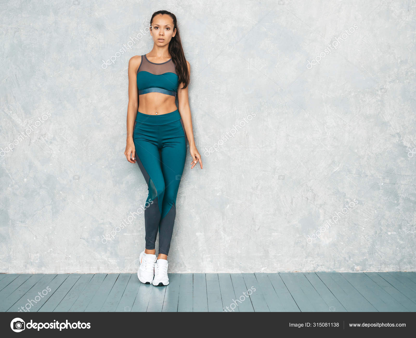 Portrait of confident fitness woman in sports clothing looking