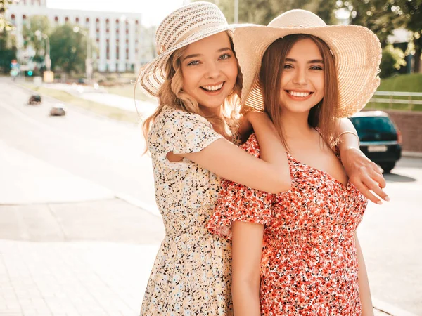 两个年轻美丽的嬉皮士女孩穿着时髦的夏装 性感无忧无虑的女人头戴帽子站在街上 快乐和拥抱的正面模型 他们都疯了 — 图库照片
