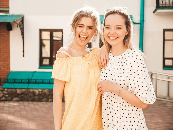 两个穿着时髦夏装的年轻漂亮的嬉皮士女孩 戴着太阳镜在街上摆出一副无忧无虑的性感女人的模样 有乐趣和拥抱的正面模型 — 图库照片