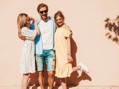 Sokakta poz veren üç genç arkadaş grubu. Moda adamı ve sıradan yaz kıyafetleri giymiş iki tatlı kız. Gülümseyen mankenler güneş gözlükleriyle eğleniyorlar. Neşeli kadınlar ve erkekler çıldırıyor.