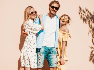 Sokakta poz veren üç genç arkadaş grubu. Moda adamı ve sıradan yaz kıyafetleri giymiş iki tatlı kız. Gülümseyen mankenler güneş gözlükleriyle eğleniyorlar. Neşeli kadınlar ve erkekler çıldırıyor.