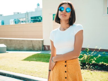 Yazın hippi kıyafetleri içinde gülümseyen güzel esmer modelin portresi. Sokakta poz veren modaya uygun bir kız. Eğlenceli ve olumlu kadın eğleniyor.