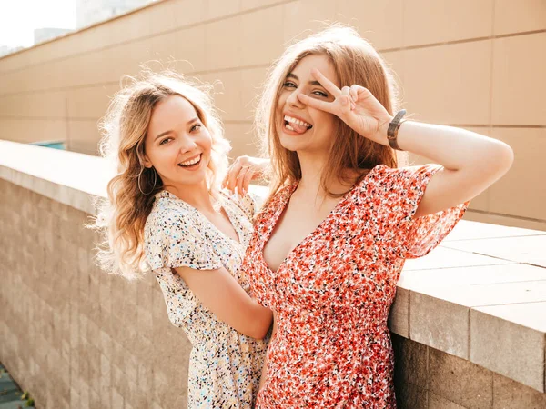 两个年轻美丽的嬉皮士女孩穿着时髦的夏装 性感无忧无虑的女人在街上摆背景 有乐趣的正面榜样和显示和平的标志 — 图库照片