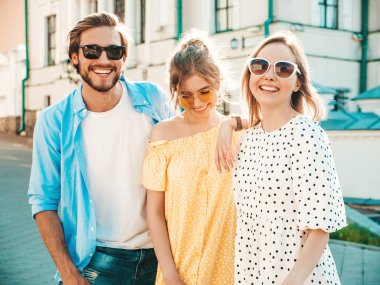Sokakta poz veren üç genç arkadaş grubu. Moda adamı ve sıradan yaz kıyafetleri giymiş iki tatlı kız. Gülümseyen modeller güneş gözlükleriyle eğleniyorlar. Neşeli kadınlar ve Susnet 'teki adam.