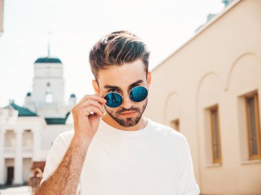 Yakışıklı, kendine güvenen, stil sahibi, Lambersex mankeni portresi. Beyaz tişört giyen adam. Sokakta güneş gözlükleriyle poz veren modacı erkek.