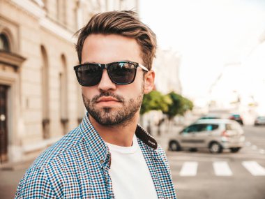 Yakışıklı, kendine güvenen, stil sahibi, Lambersex mankeni portresi. Beyaz tişört giyen adam. Sokakta güneş gözlükleriyle poz veren modacı erkek.