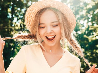 Moda bir yaz elbisesi içinde gülümseyen güzel hippi kız portresi. Günbatımında şapkayla parkta sokakta poz veren kaygısız seksi kadın. Açık havada pozitif model.