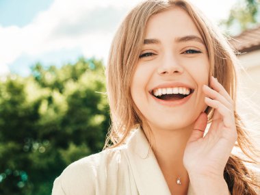 Güzel, gülümseyen sarışın bir modelin yaz hippi kıyafetleri içinde yakın plan portresi. Sokakta poz veren modaya uygun bir kız. Komik ve pozitif kadın dışarıda eğleniyor.