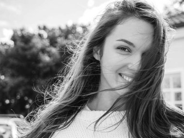 Güzel, gülümseyen esmer modelin yakın plan portresi. Sokakta poz veren modaya uygun bir kız. Komik ve pozitif kadın dışarıda eğleniyor.