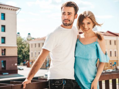 Gülümseyen güzel bir kadın ve yakışıklı erkek arkadaşının portresi. Günlük kot pantolon giymiş bir kadın. Mutlu, neşeli bir aile. Kadın eğleniyor. Sokakta poz veren çift