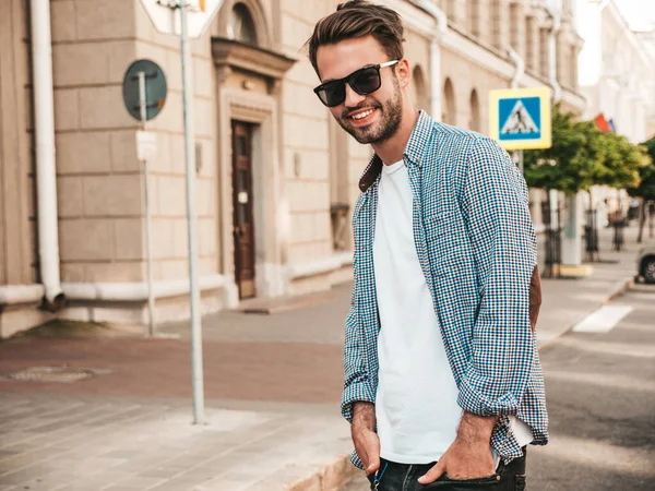 ハンサムな笑顔スタイリッシュなヒップスターランバーセクシュアルモデルの肖像 ファッション男性はサングラスで通りの背景にポーズ — ストック写真