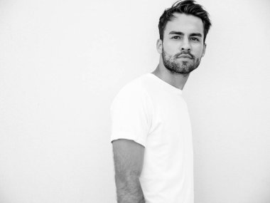 Yakışıklı, kendine güvenen, stil sahibi, Lambersex mankeni portresi. Beyaz tişört giyen adam. Moda erkeği dışarıda duvarın yanında sokak arkasında poz veriyor.