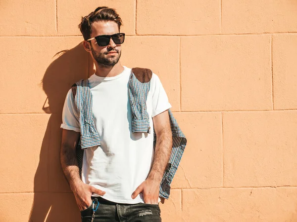 Yakışıklı, kendine güvenen, stil sahibi, Lambersex mankeni portresi. Beyaz tişört giyen adam. Moda erkeği sokakta poz veriyor.