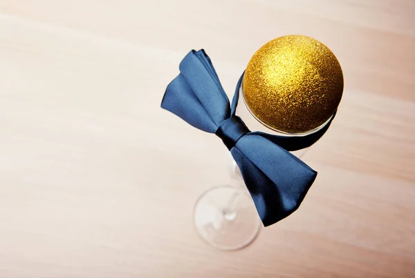 New Year Gold Toy Ball Empty Champagne Glass Bow Tie — Stock Photo, Image