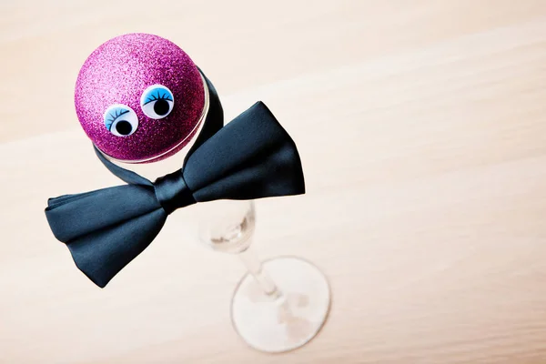 New Year Pink Toy Ball Empty Champagne Glass Bow Tie — Stock Photo, Image
