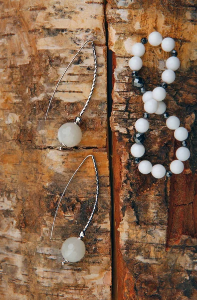 月光石银色耳环陶瓷手镯木背景 — 图库照片