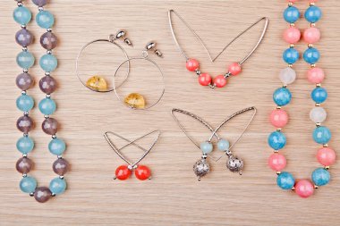 gümüş küpe yüzük murano cam akik taş boncuk ahşap masa