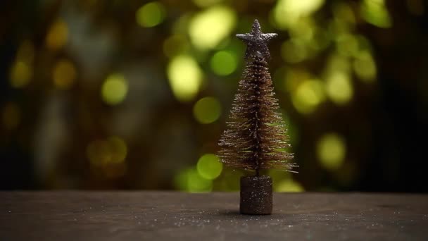 Miniature Fir Tree Wooden Table Gold Bokeh Footage — Stock Video