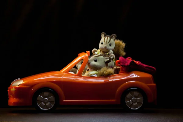 Zabawka Samochód Czerwony Wiewiórka Rodziny Ciemne Tło — Zdjęcie stockowe