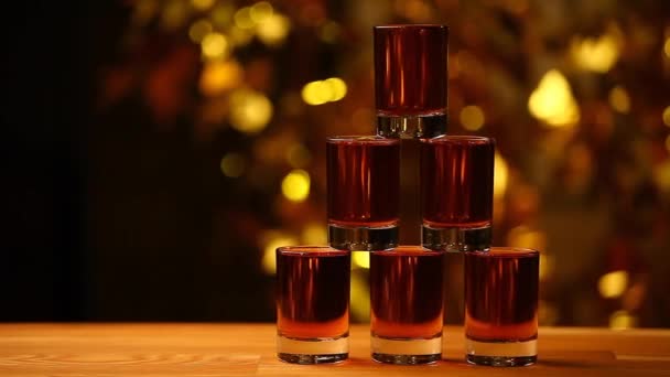 Cognac Shot Piramide Tavolo Legno Oro Bokeh Filmato — Video Stock
