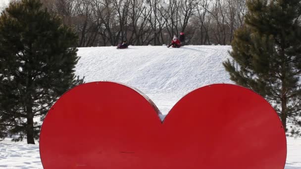 Κόκκινη Μεταλλική Καρδιά Χειμερινό Πάρκο Παιδιά Παίζουν Βίντεο — Αρχείο Βίντεο