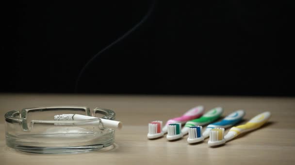 Cepillo Dientes Cigarrillo Mesa Madera Fondo Oscuro Nadie Metraje — Vídeos de Stock