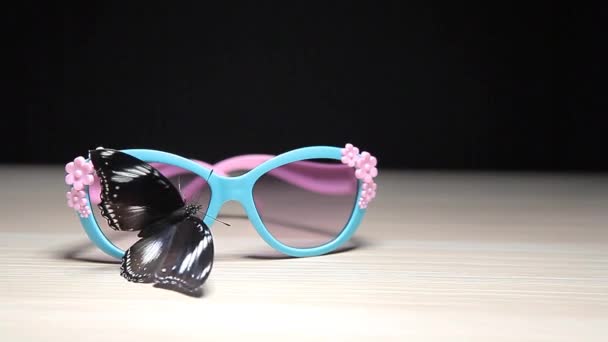 Sunglasses Butterfly Wooden Table Dark Background Footage — Stock Video