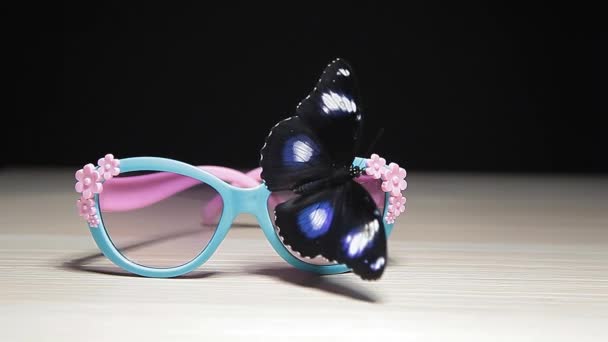 Sunglasses Butterfly Wooden Table Dark Background Footage — Stock Video