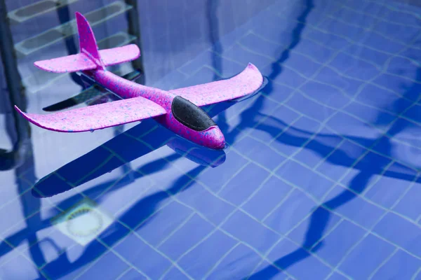 粉红色玩具飞机游泳池没有人 — 图库照片
