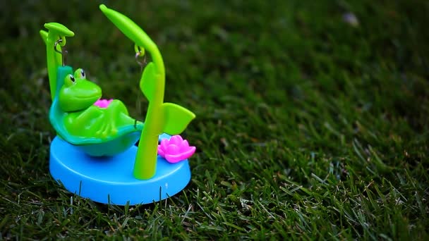 塑料青蛙吊床草背景高清镜头 — 图库视频影像