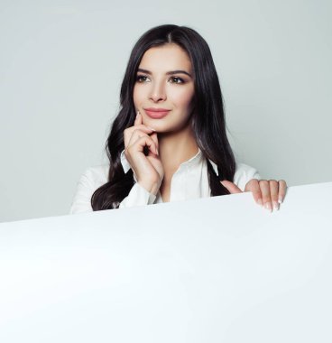 Düşünme ve beyaz boş boş kağıt afiş arka plan tutarak kendine güvenen kadın 