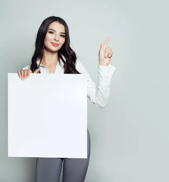 Amichevole Giovane Donna Con Sfondo Bianco Vuoto Striscione Carta Puntando — Foto Stock