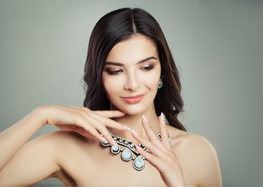 Güzellik moda portre sevimli kadınla dalgalı kahverengi saç ve takı kolye