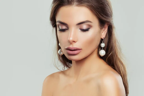 Woman with perfect makeup and pearls earrings, beauty portrait