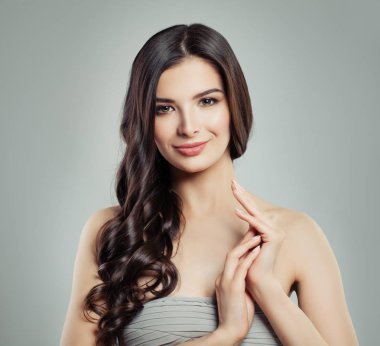 Genç esmer kadın makyaj ve uzun sağlıklı dalgalı saç gülümseyen, moda güzellik portresi