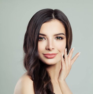 Mutlu esmer kadın. Makyaj, uzun sağlıklı kıvırcık saç modeli ve manikür. Genç kadın yüz portre portre 