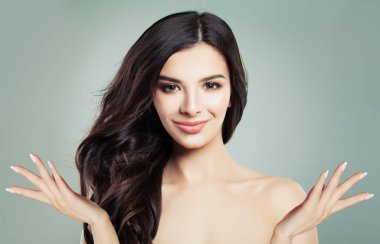 Sağlıklı cilt ve gülümseyen ve boş kopya alanı iki açık ellerde, güzellik portre gösterilen uzun dalgalı saç modeli ile genç mutlu kadın Spa modeli. Ürün yerleştirme ve pazarlama kavramı reklam
