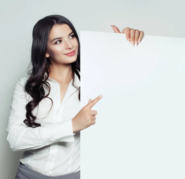 Leende Kvinna Med Vit Blank Papper Banner Bakgrund Pekar Tom — Stockfoto