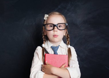 Blackboard arka plan Akıllı çocuk. Mutlu küçük kız bardaklarda kırmızı kitap ile. Okula dönüş
