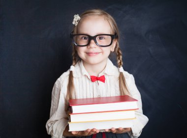 Tebeşir tahtası arka plan üzerinde kitap ile güzel kız öğrenci. Okula dönüş