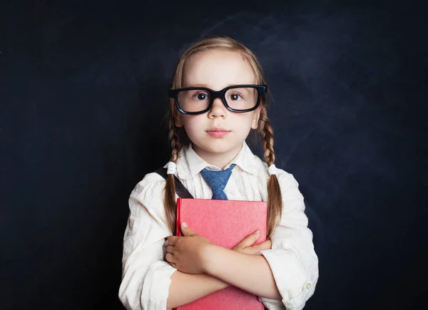 チョーク ボードの背景に赤い本と制服の服でスマートな子女の子 幸せな子供時代 小学校のレッスン コンセプトに戻る — ストック写真