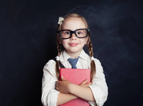 チョーク ボードの背景に本と制服の服で笑顔の子女の子 スマートな子供の肖像画 幸せな子供時代 小学校のレッスン コンセプトに戻る — ストック写真