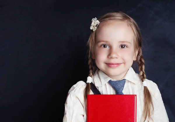 スクー制服の服の本を読んで 笑顔のかわいい女の子 小学校のレッスンと教育の概念に戻る — ストック写真