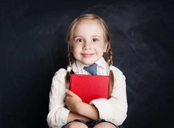 本でかわいい女の子 コピー スペースを持つ空の黒板背景に幸せな子供 — ストック写真