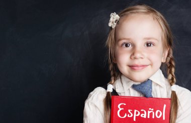 Küçük çocuk öğrenci sınıf kara tahta afiş arka plan kopya alanı ile İspanyolca öğrenme