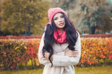 Sonbahar kadın portre. Şirin kız giyiyor şapka ve atkı pembe ve sonbaharda açık havada park