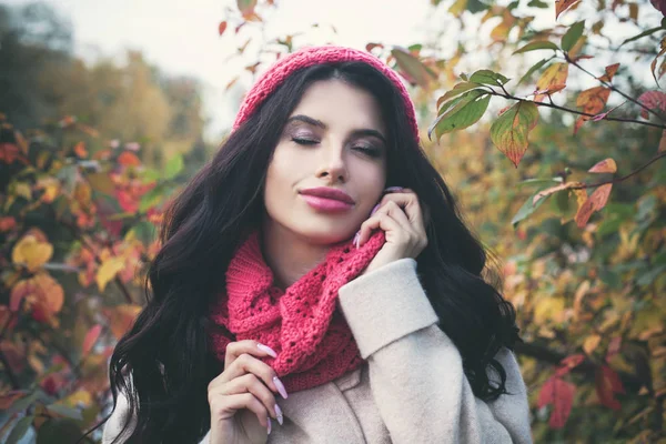 Kırmızı akçaağaç yaprağı açık havada tutarak uzun siyah saçlı güzel sonbahar kadın. Sonbahar Park güzel kız